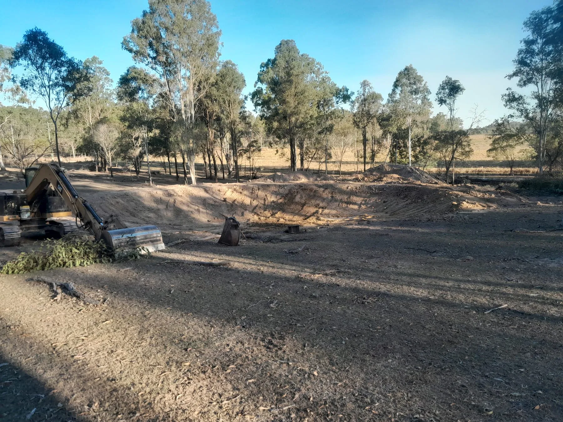 The excavator digging out a new dam