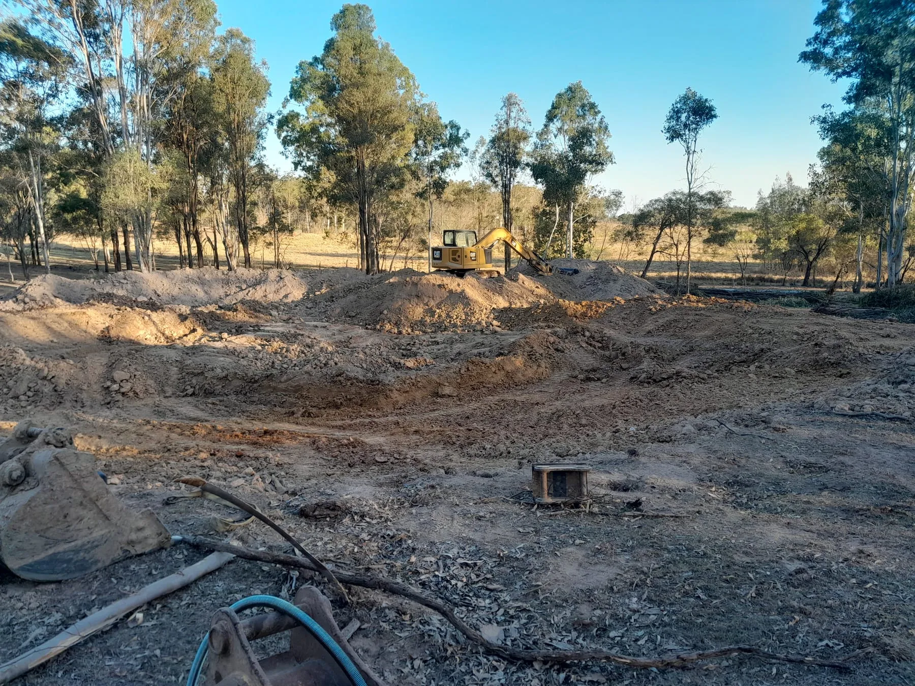 The dam being excavated, with the excavator in the distance